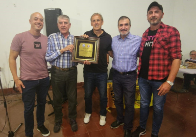 Dirigentes de la AAVF y la entrega de la plaqueta recordatoria a Quique Cabral. 